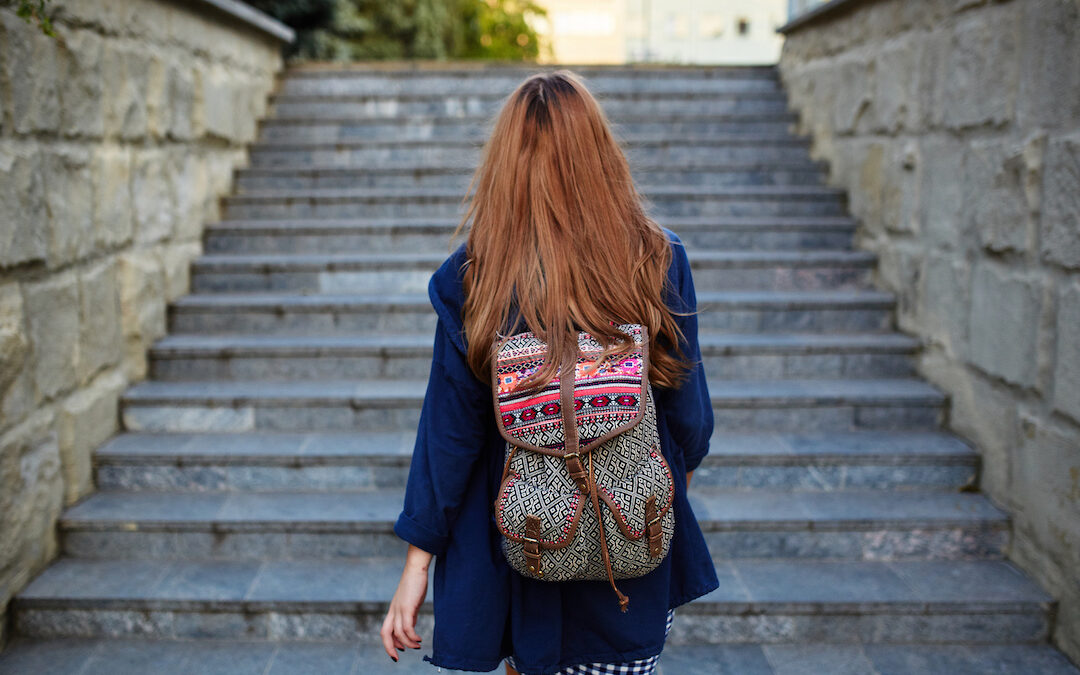 Student girl with a backpack climbing stairs